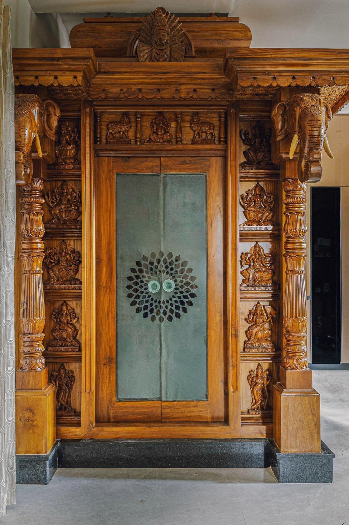 Carved teak mandir with glass doors