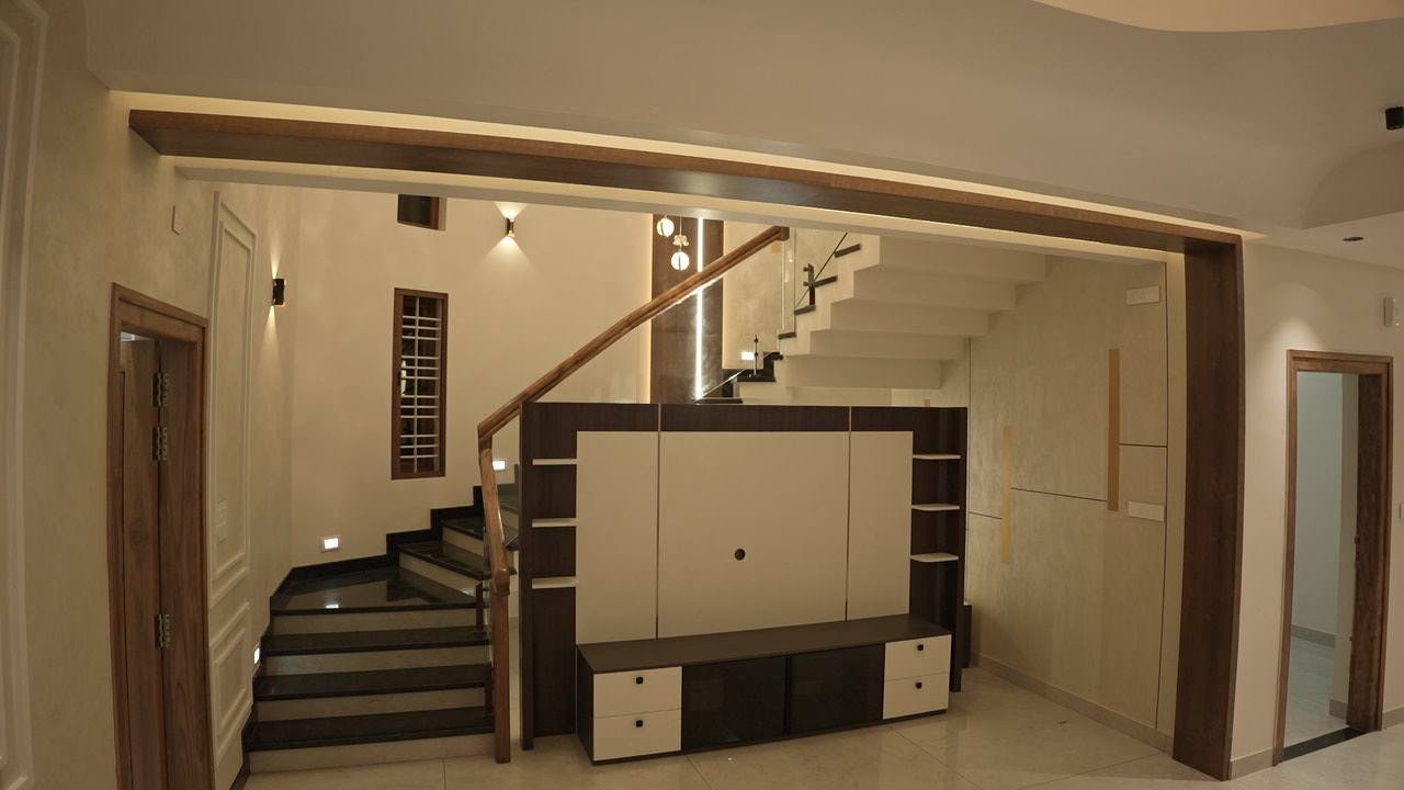 Family living with a white media wall beside an open timber-and-glass staircase