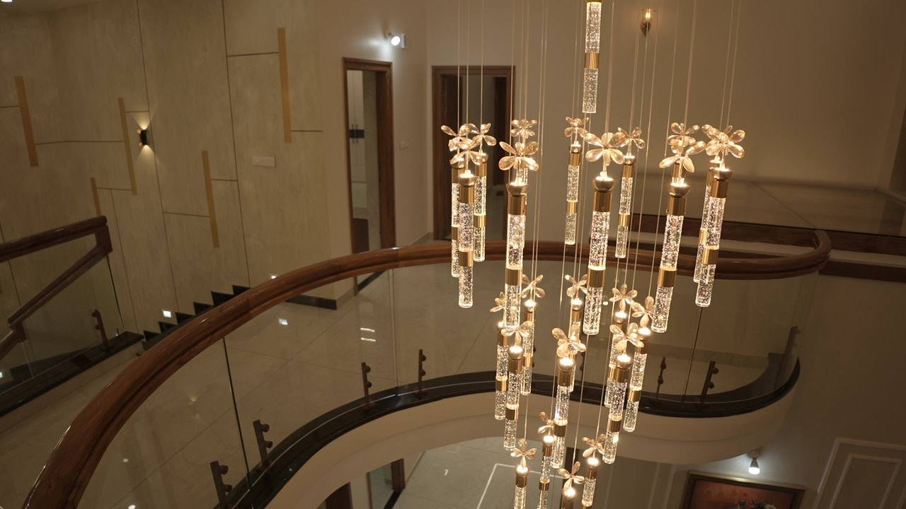 Chandelier strands beside the curved timber stair rail