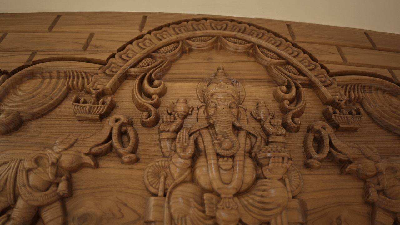 Hand-carved Ganesha relief above the pooja doorway