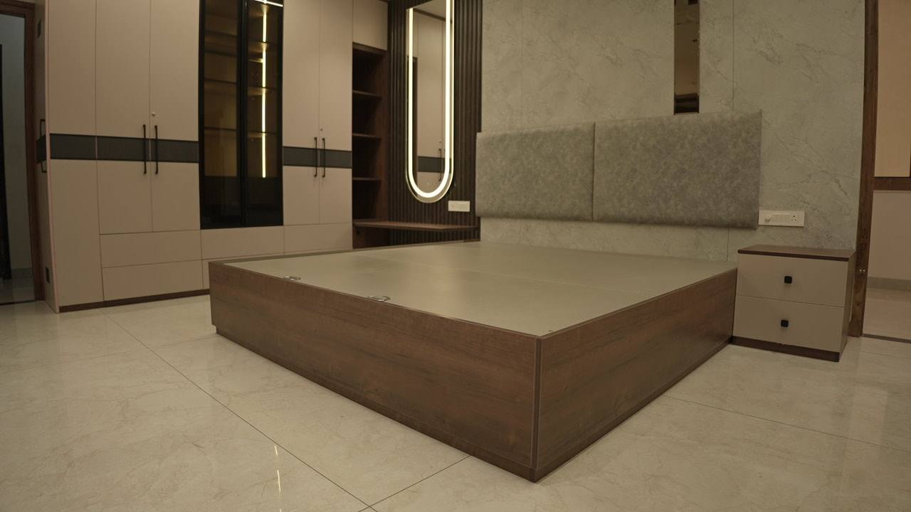 Master bedroom bed against an upholstered headboard wall